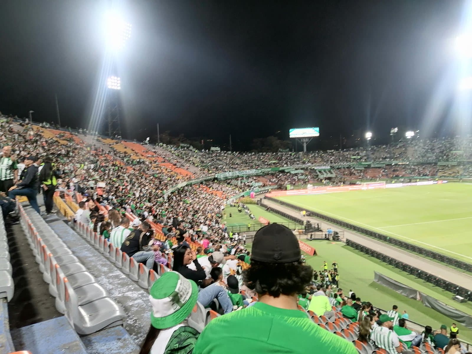Atlético Nacional fans in green fill the stands under floodlights at Estadio Atanasio Girardot