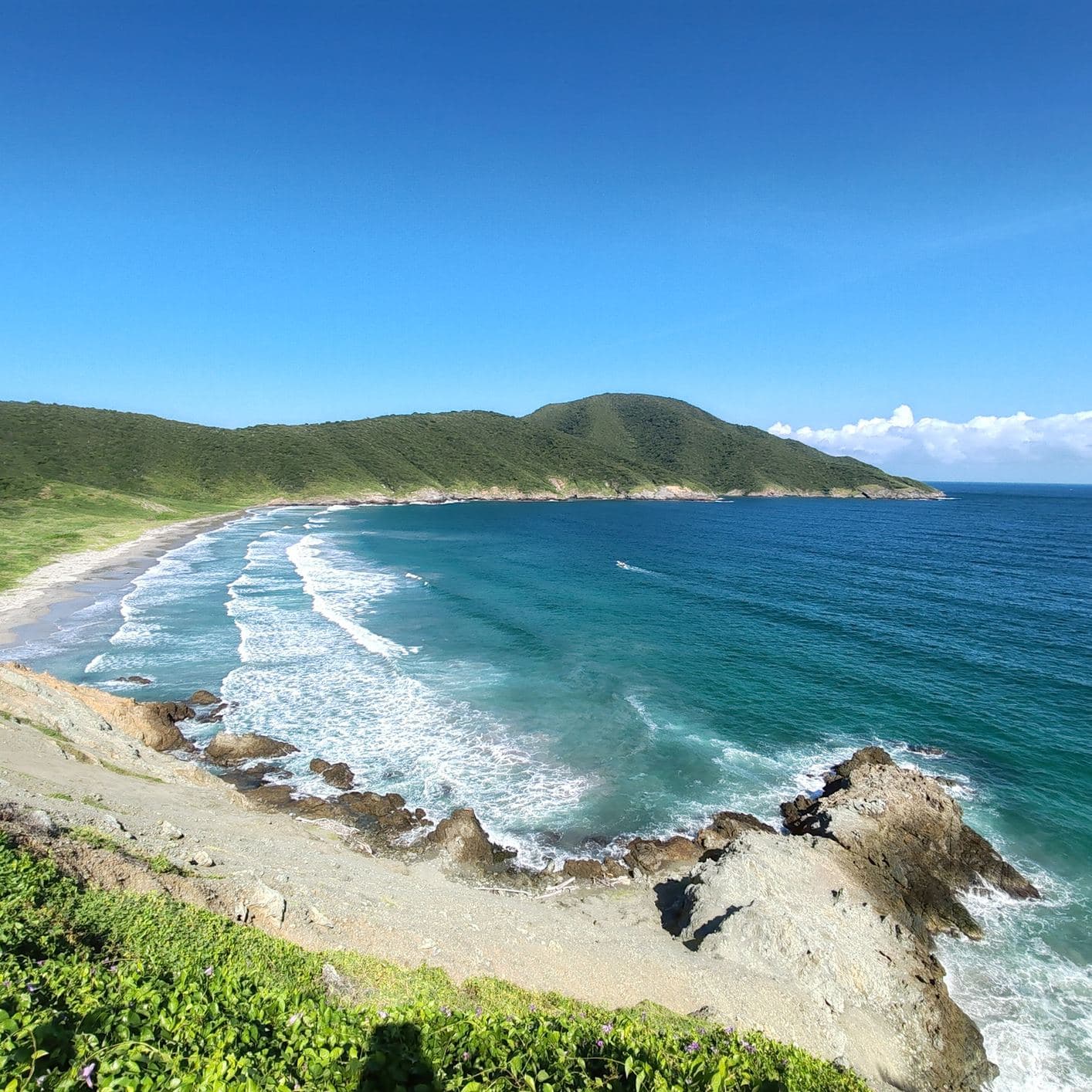 Olas de azul profundo rompen en una playa dorada y curva dentro del Parque Nacional Tayrona