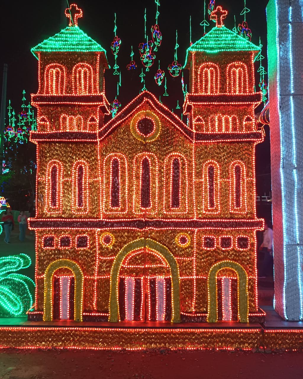Cathedral facade outlined in thousands of red, green and gold Christmas lights at Parques del Río, Medellín