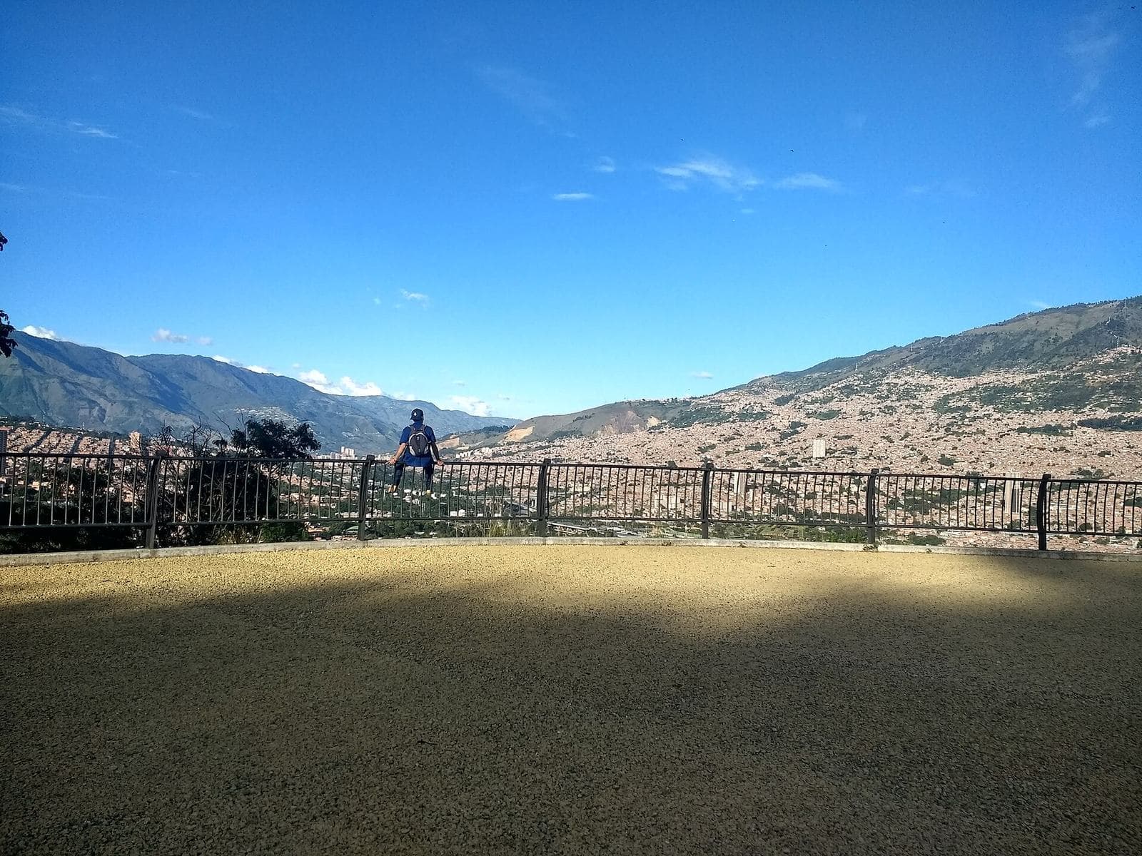 Baranda de mirador en el Cerro El Volador con el valle y las montañas de Medellín bajo un cielo azul