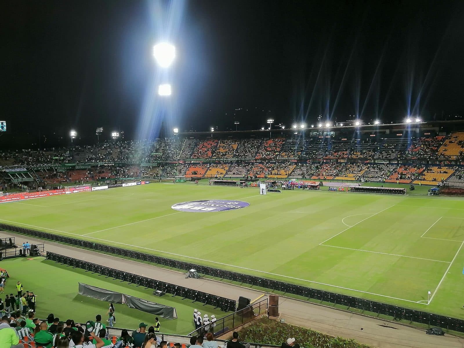 Partido nocturno con reflectores en la cancha verde del Estadio Atanasio Girardot en Medellín
