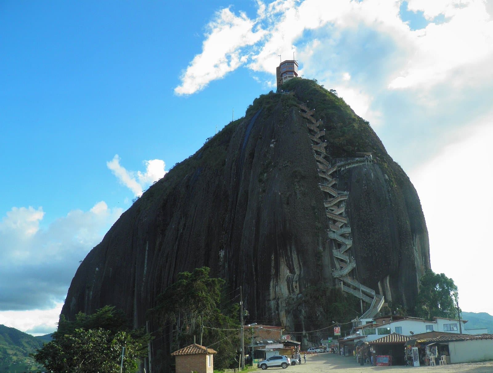 El monolito de granito de la Piedra del Peñol con su escalera en zigzag bajo un cielo azul brillante