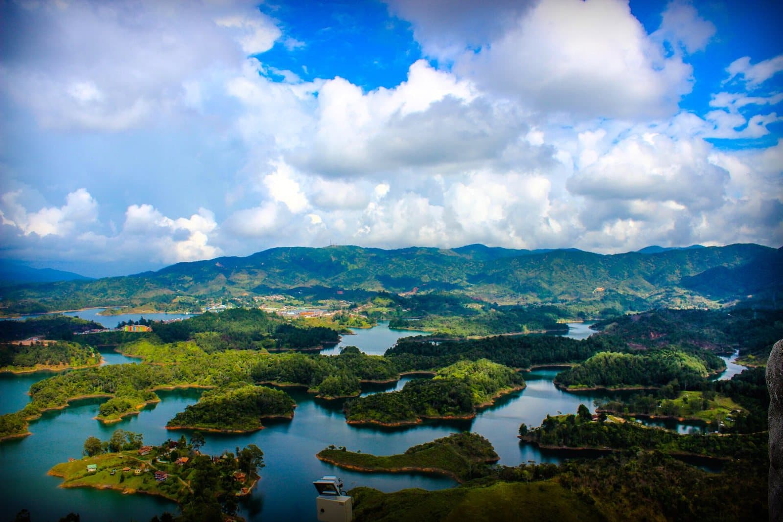 Islas verdes y ensenadas sinuosas del embalse de Guatapé bajo nubes espectaculares, vistas desde El Peñol