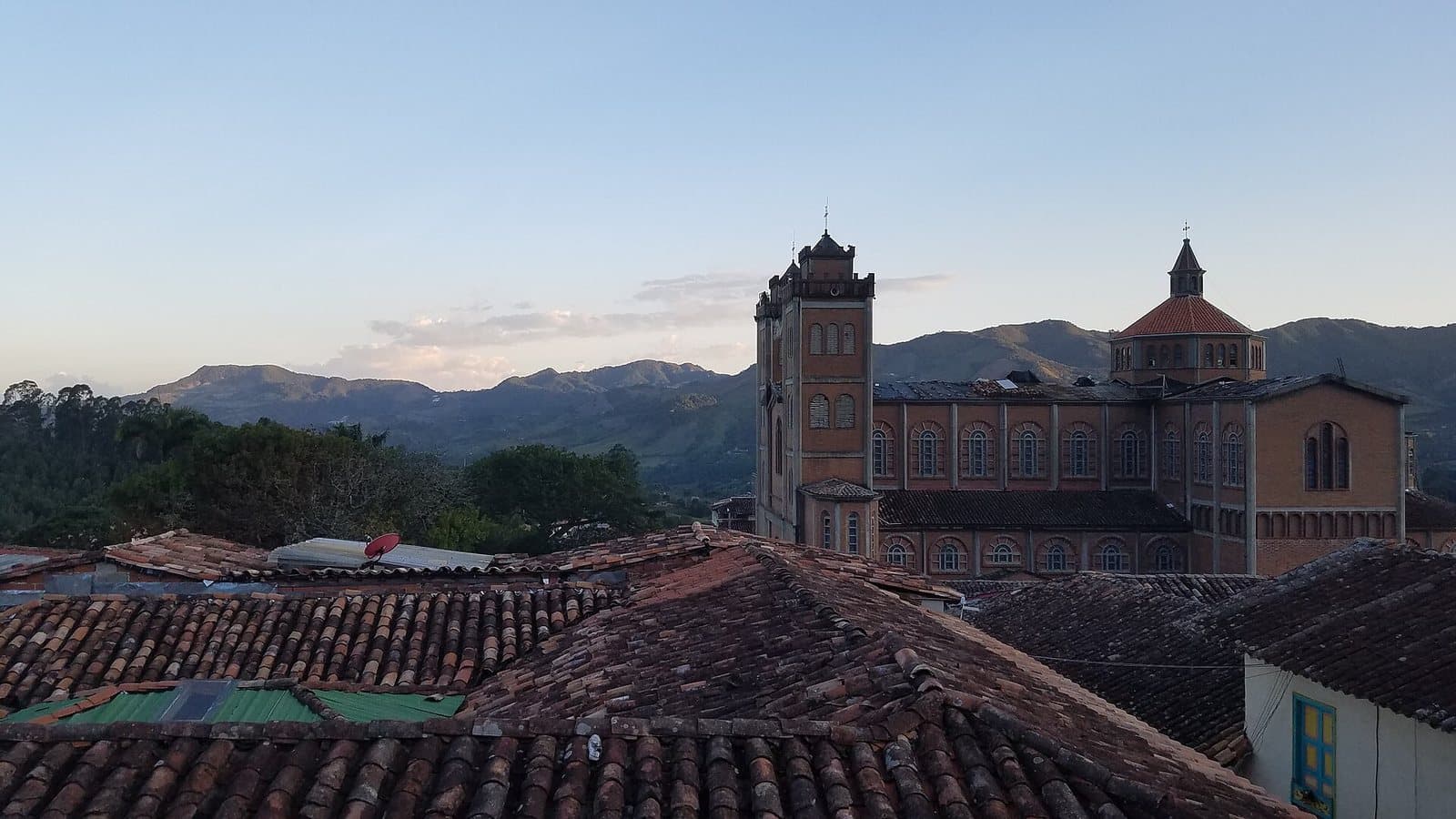 Las cúpulas de la catedral de Jericó sobre tejados de terracota, con las montañas al atardecer