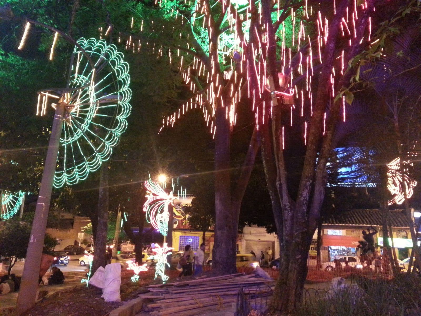 Christmas lights cascading through the tall trees of Parque Lleras on a December night in El Poblado