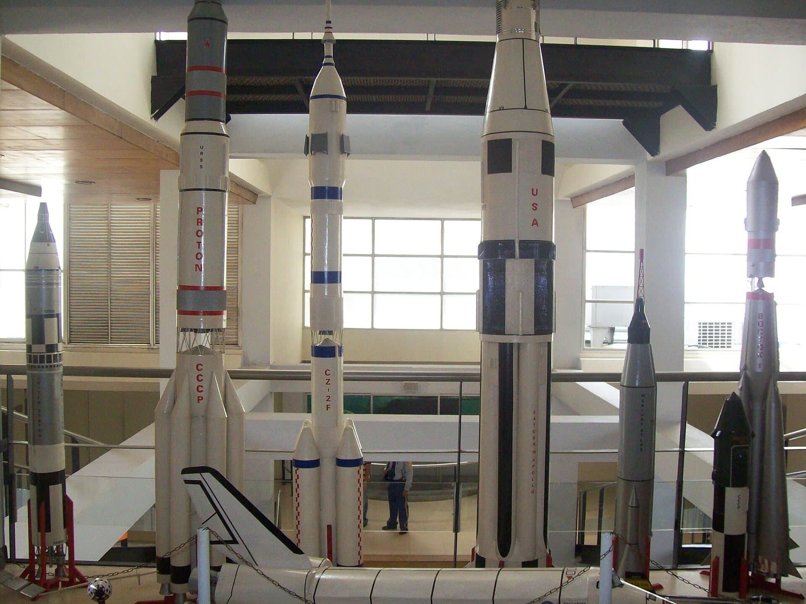 Tall model space rockets displayed in the bright exhibition hall of the Planetario de Medellín