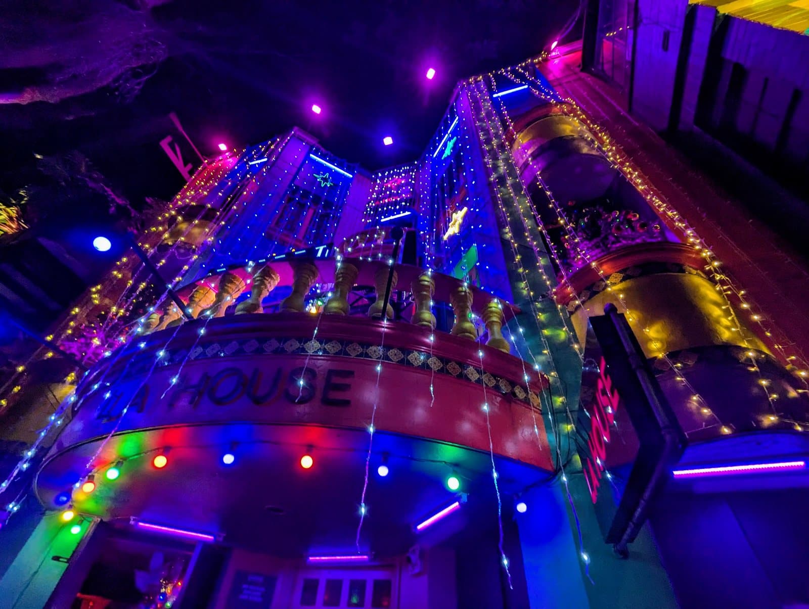 Multicolored lights blazing across the facade of a Provenza nightclub on a Medellín evening