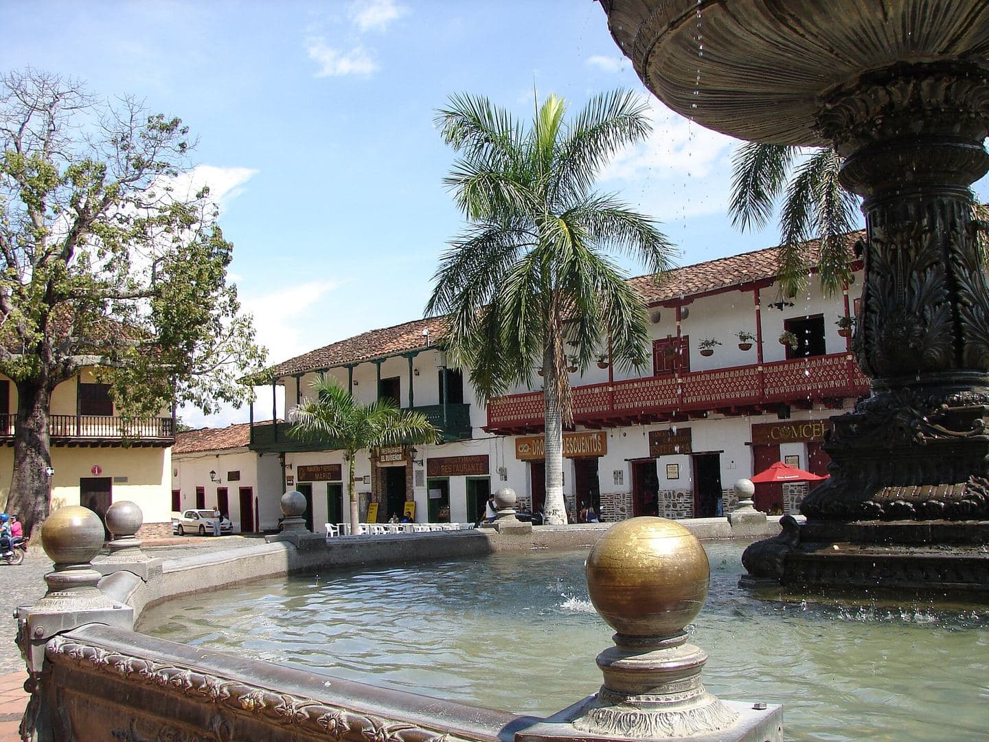Palm trees and whitewashed colonial houses around the fountain in Santa Fe de Antioquia's main square