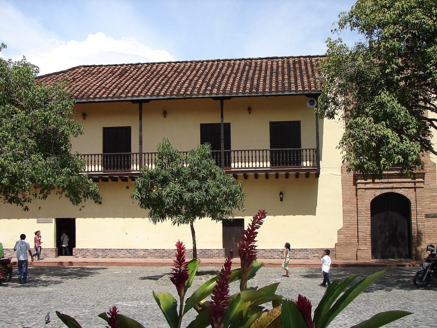 Colonial Alcaldía with wooden balconies and red heliconias on the plaza of Santa Fe de Antioquia
